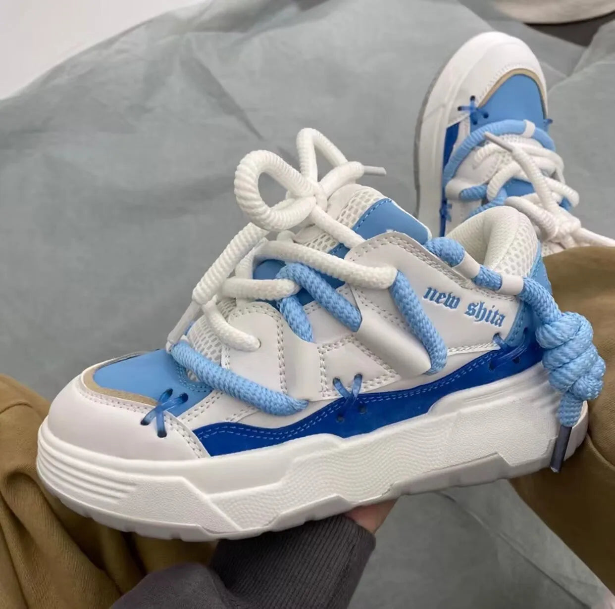 Grey women's chunky retro platform sneakers with thick rubber sole and lace-up front.