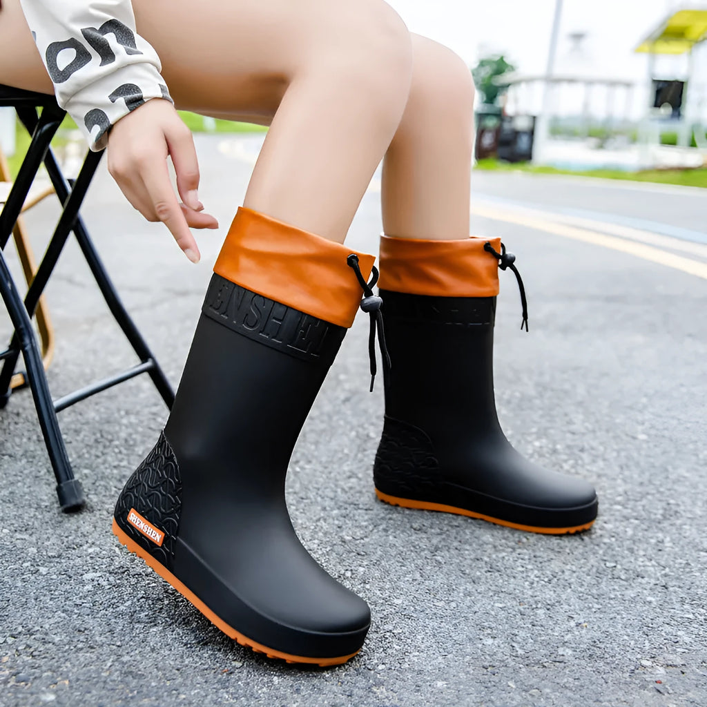 Women's solid colour PVC rain boots with non-slip sole in apricot, black, brown, or pink waterproof mouth.