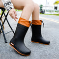 Women's solid colour PVC rain boots with non-slip sole in apricot, black, brown, or pink waterproof mouth.