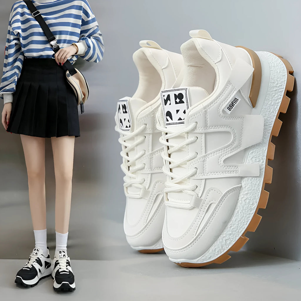 Low top unisex running sneaker in black or white with round toe and flat rubber sole.