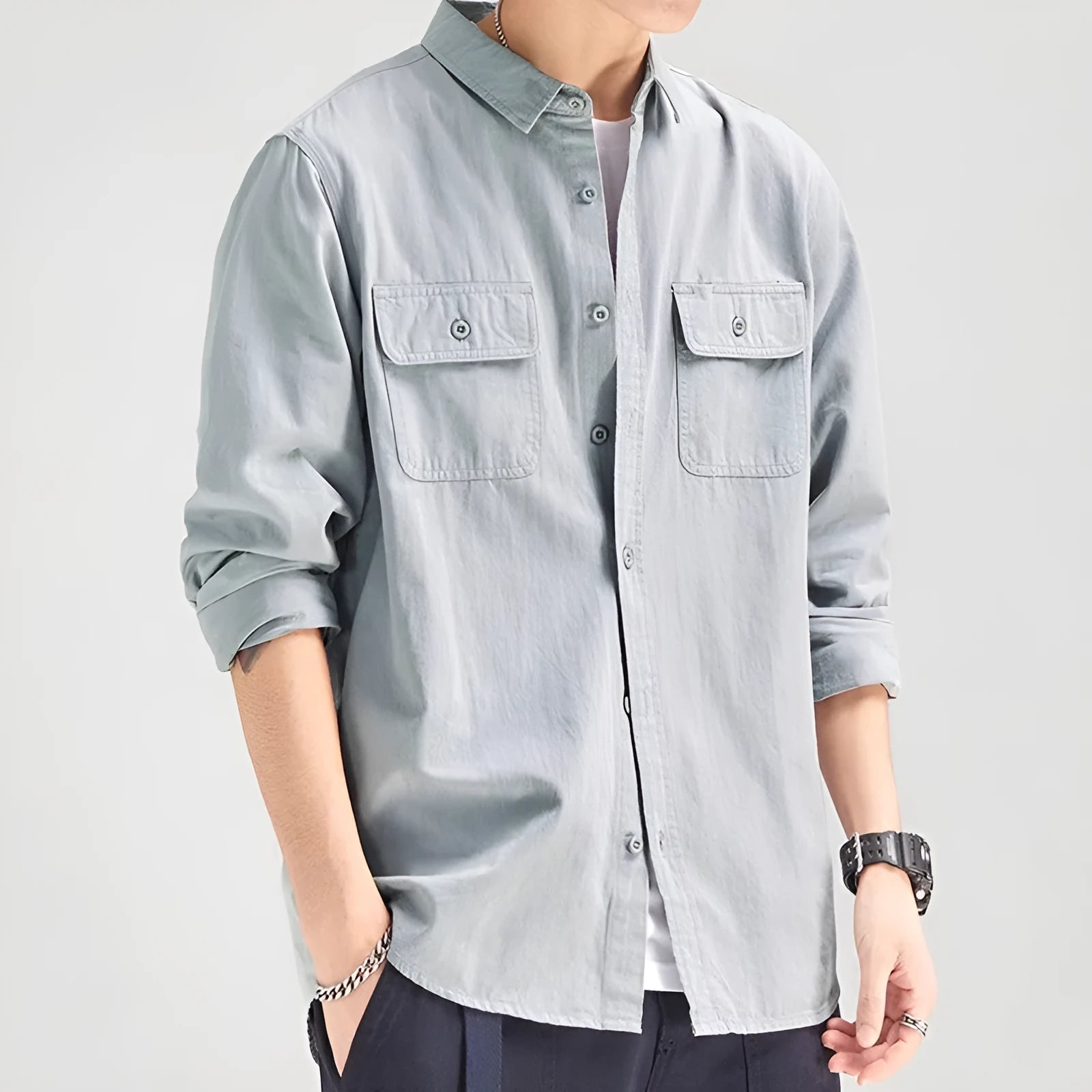 Man wearing a loose-fit light grey polyester cardigan shirt with long sleeves and an overalls design detail.