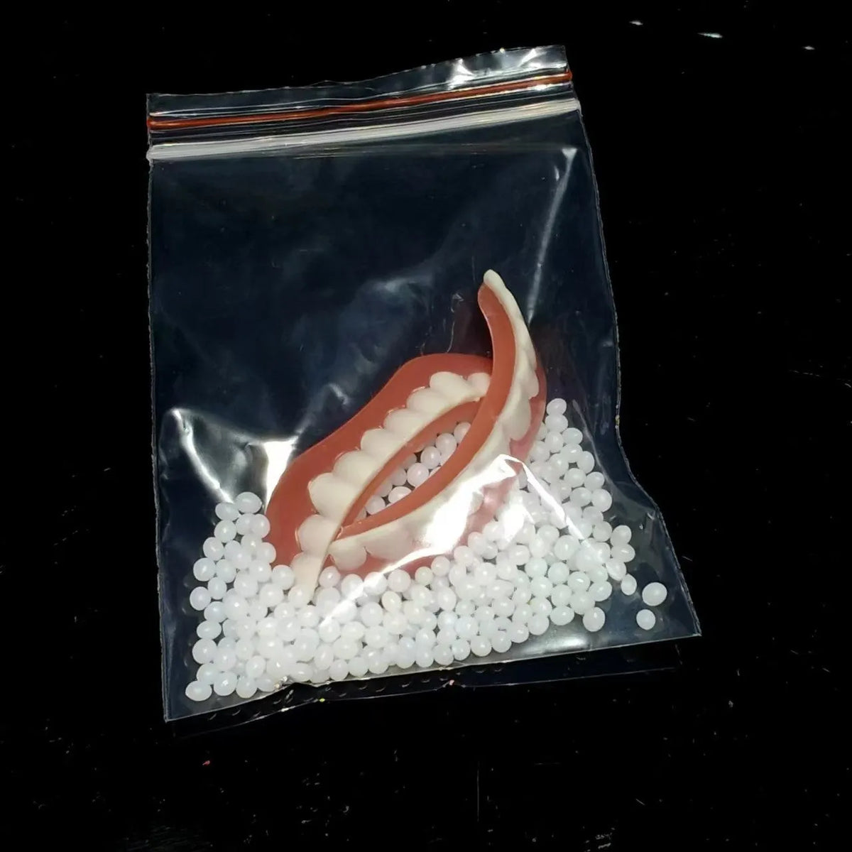 Disposable silicone simulation smile dentures with upper and lower teeth in colour box packaging