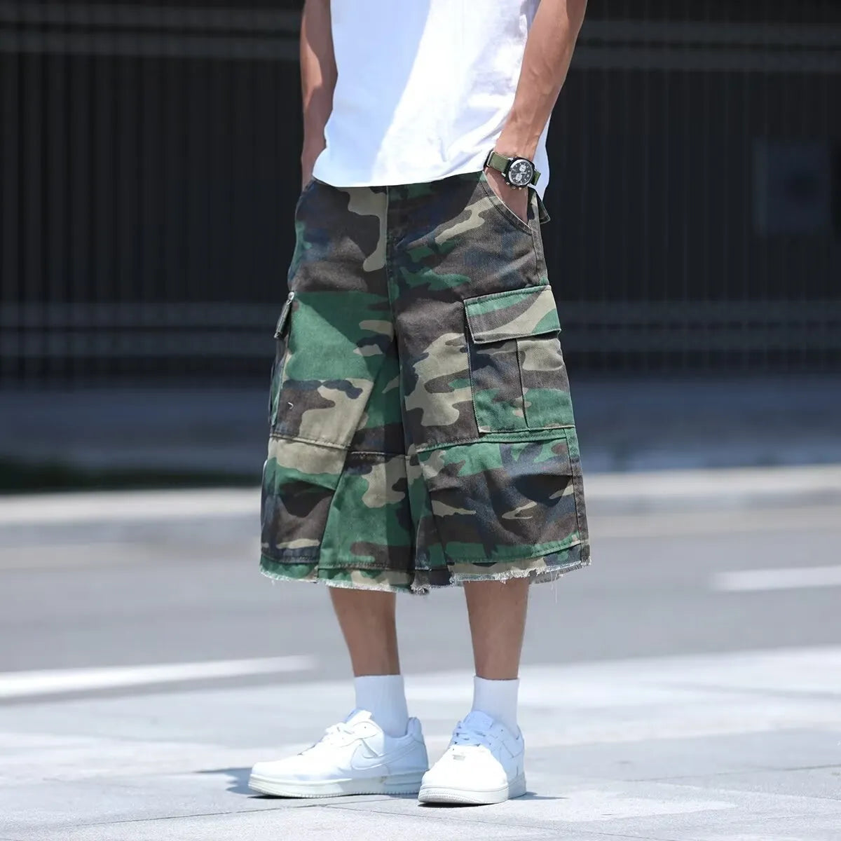 American style retro workwear loose camouflage shorts in cropped length on a neutral background.