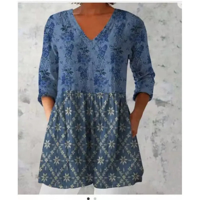 Women's printed loose-fitting dress with wide waist and three-quarter length sleeves.