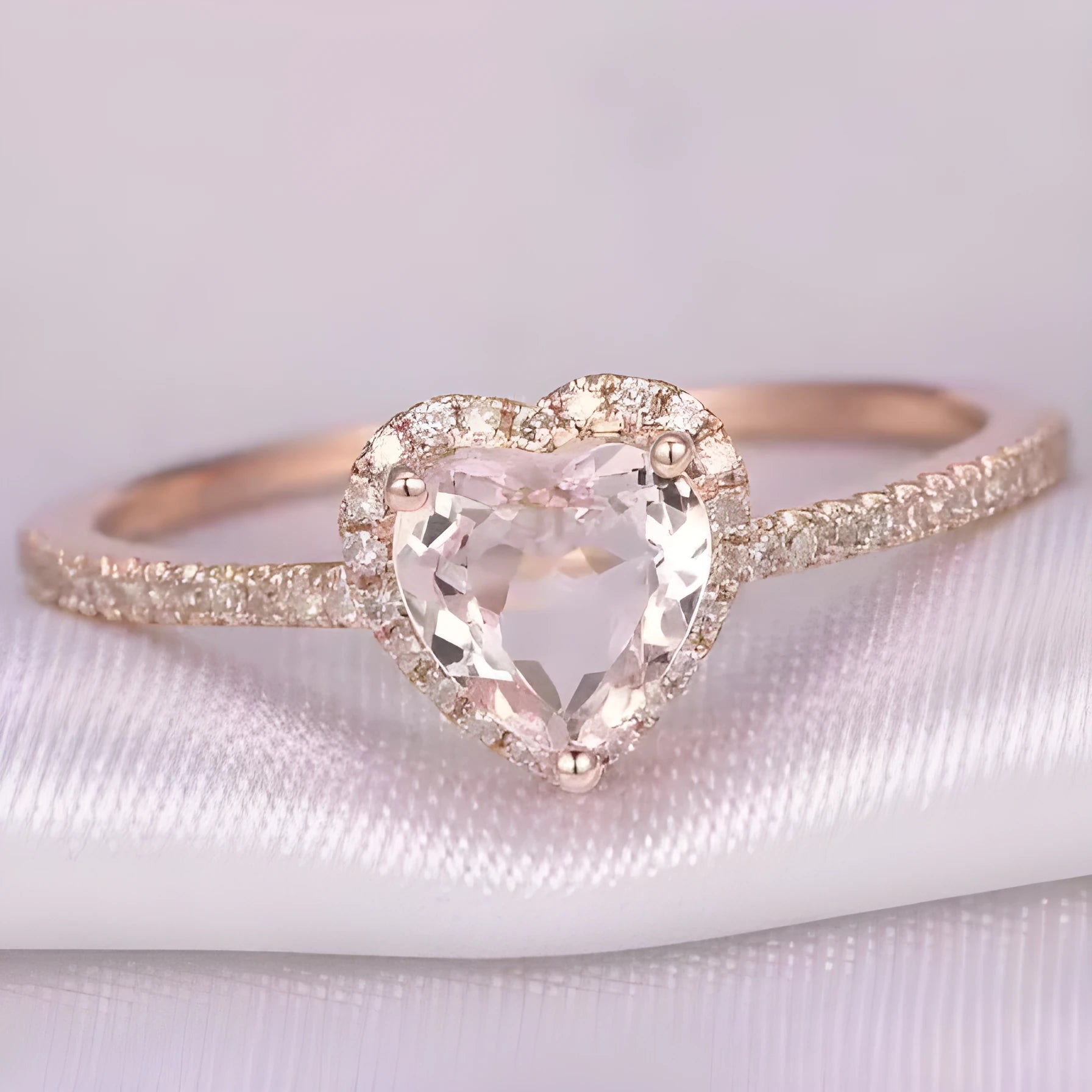 Women's heart-shaped crystal wedding ring in rose gold or silver on a white background.