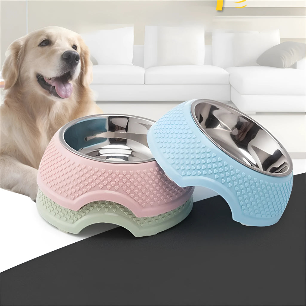 Set of four coloured stainless steel pet bowls with non-slip bases on a floor.