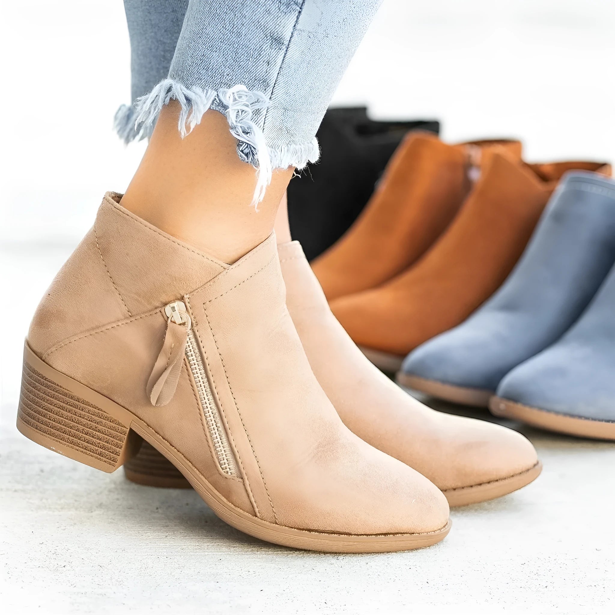 Women's blue suede Dr Martens ankle boots with a side zip and chunky heel on a white background.