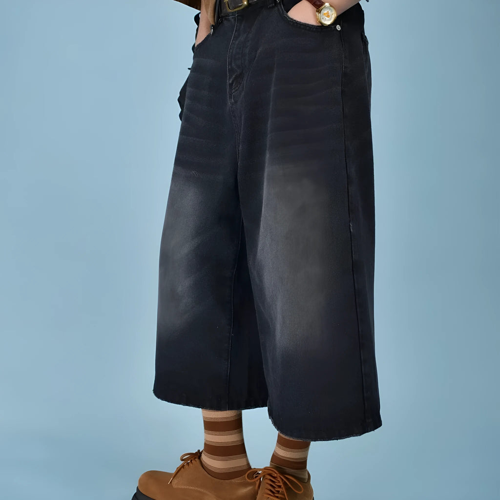 Man wearing light blue straight leg loose fit denim shorts on a summer day.