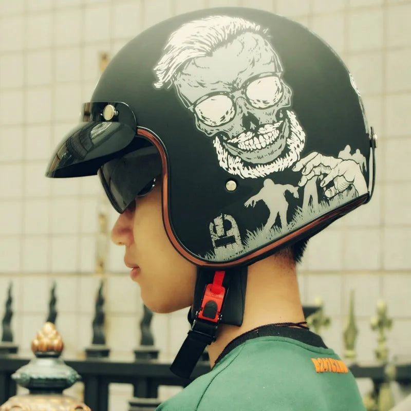Retro-style black and orange half helmet for electric bike riding on a grey background.