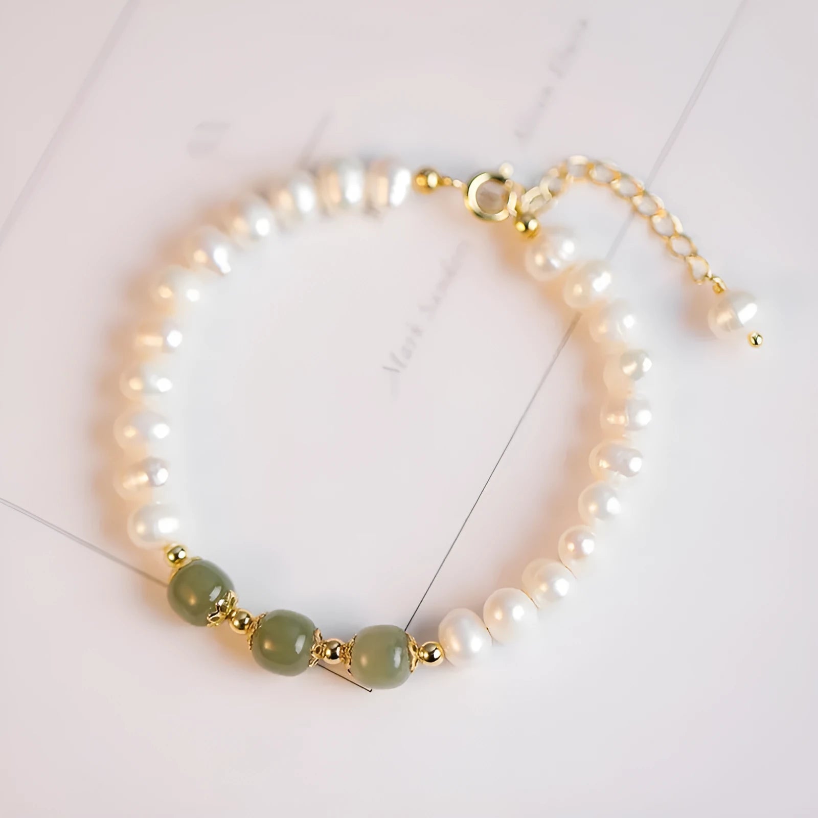 Natural freshwater pearl bracelet with diamond-shaped beads in Hetian jade colour on a wrist.