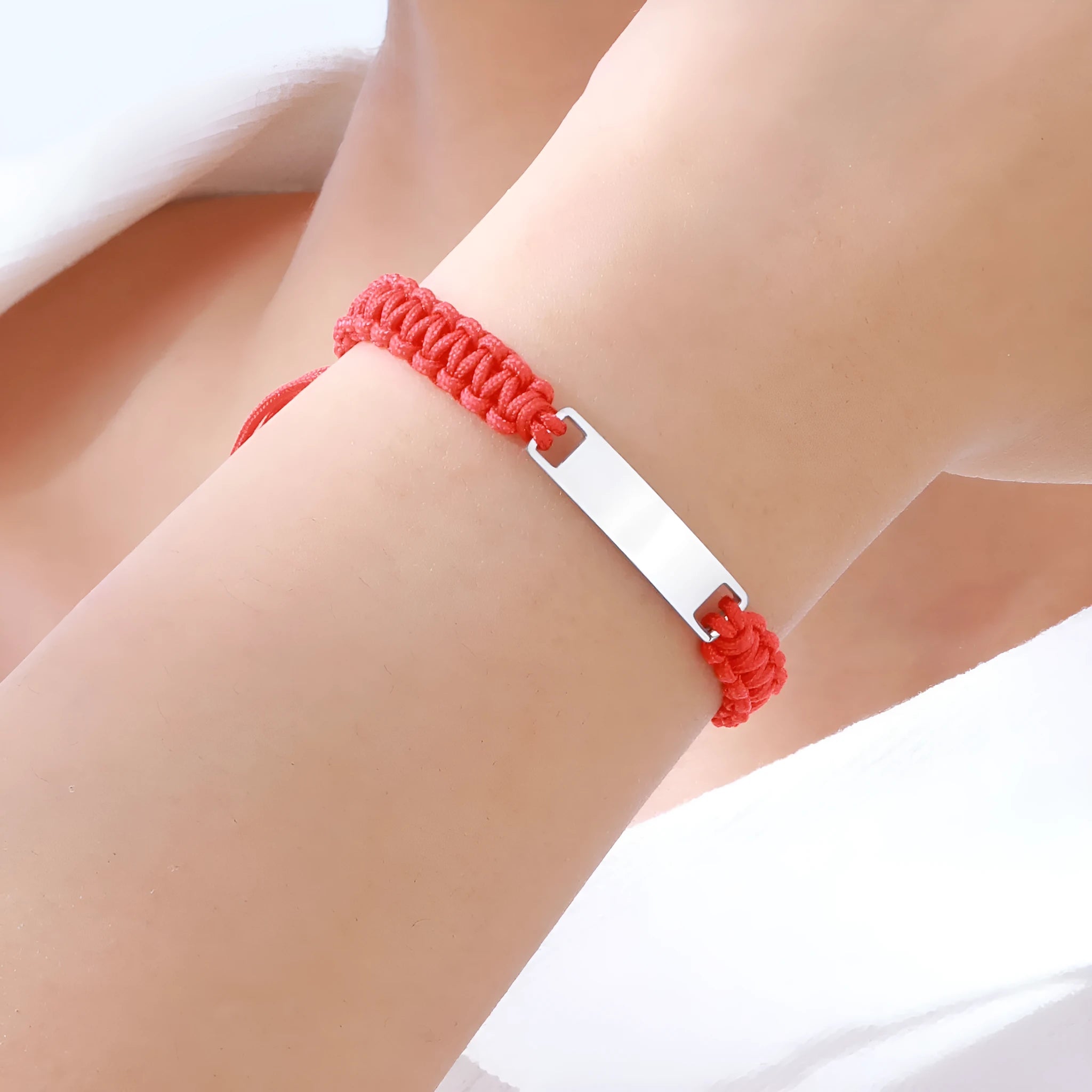 Red nylon rope woven child's bracelet with curved stainless steel brand piece in rose gold finish