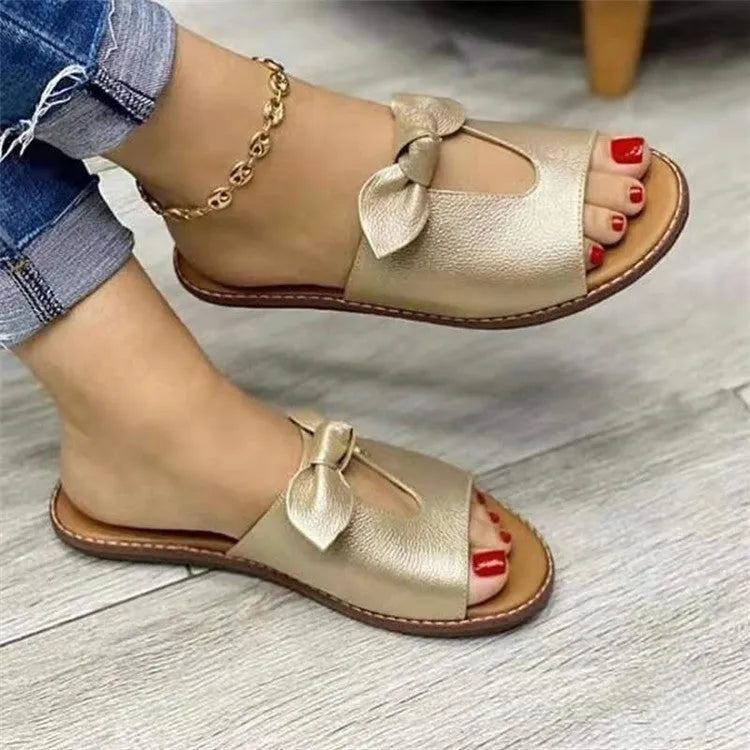 Ladies black sandals with fish mouth open toe and a decorative bow on the strap.
