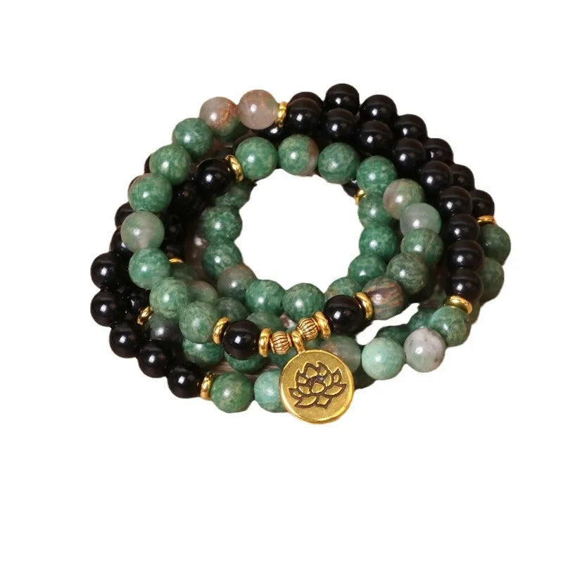 Green and black elastic beaded alloy bracelet on wrist showing natural style design