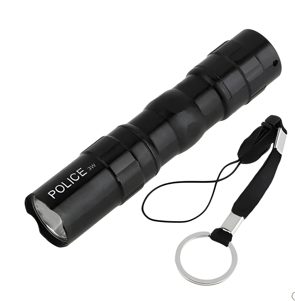 Small black aluminium LED flashlight showing compact size next to a AA battery for scale.