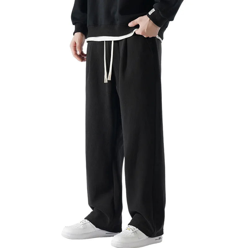 Men's loose fit apricot coloured fleece-lined sports pants with a drawstring waist on a hanger