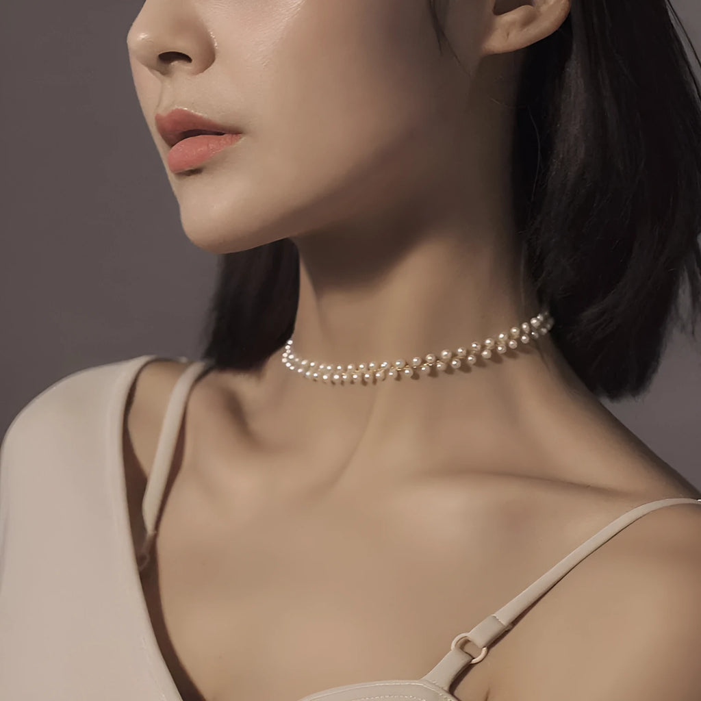 Hand-woven white pearl necklace with adjustable bean chain on display