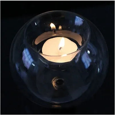 Handmade transparent round hollow glass candle holder for a tealight on a wooden table
