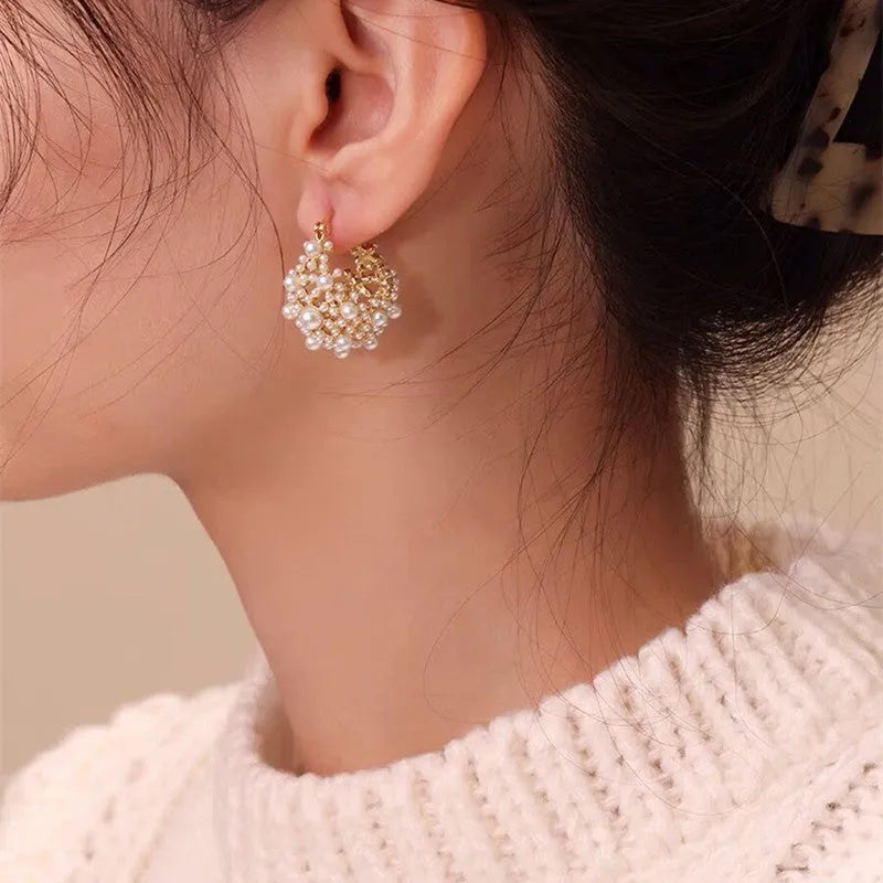 Gold-coloured copper flower basket earrings with small rice-shaped beads and pearl inlay detailing