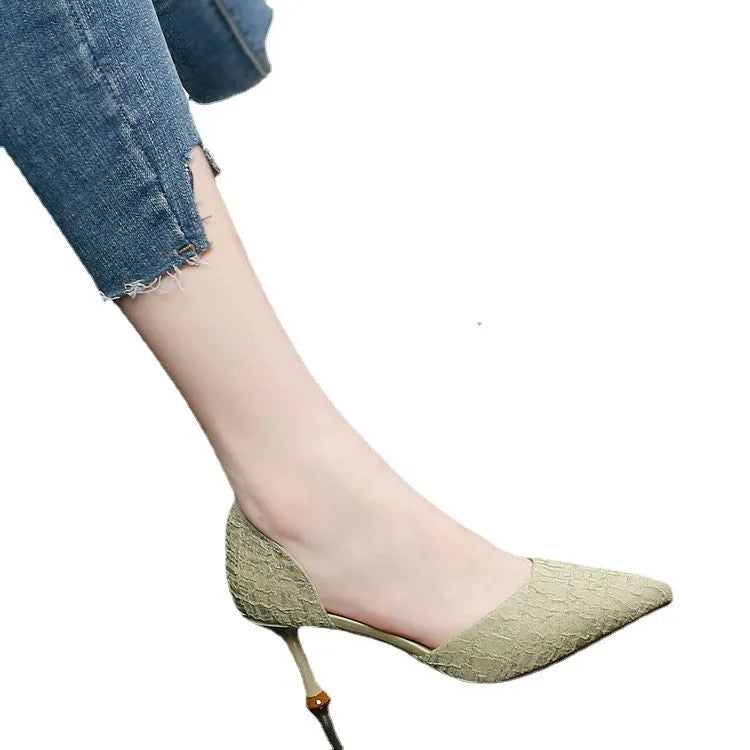 Women's black pointed toe stiletto high heels with a thin heel on a plain background.