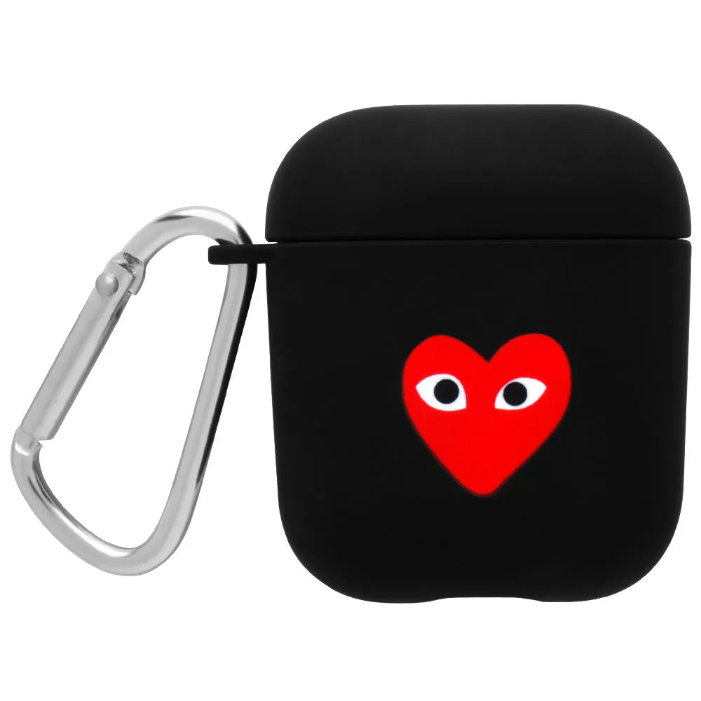 Black AirPods hard case with a smiley face design next to a pink case with a flower pattern.