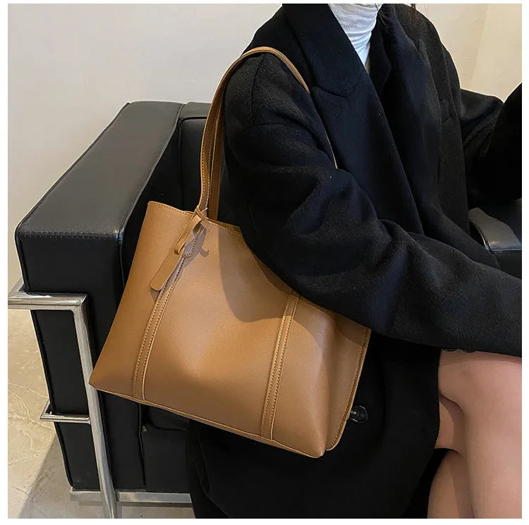 Large capacity soft leather tote bag in beige with synthetic leather lining and double shoulder straps.