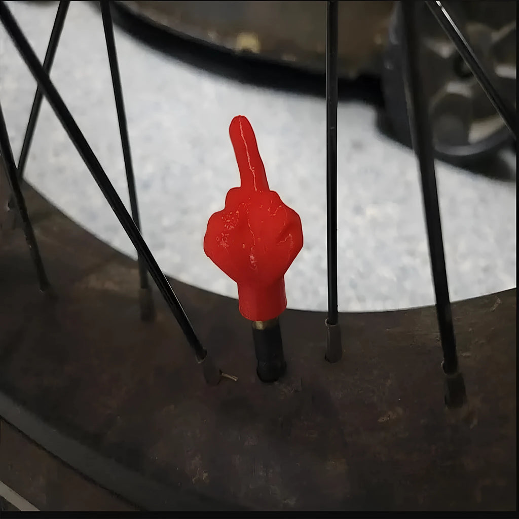 Four latex car tyre valve dust caps, shown in black and skin colour, arranged on a surface.
