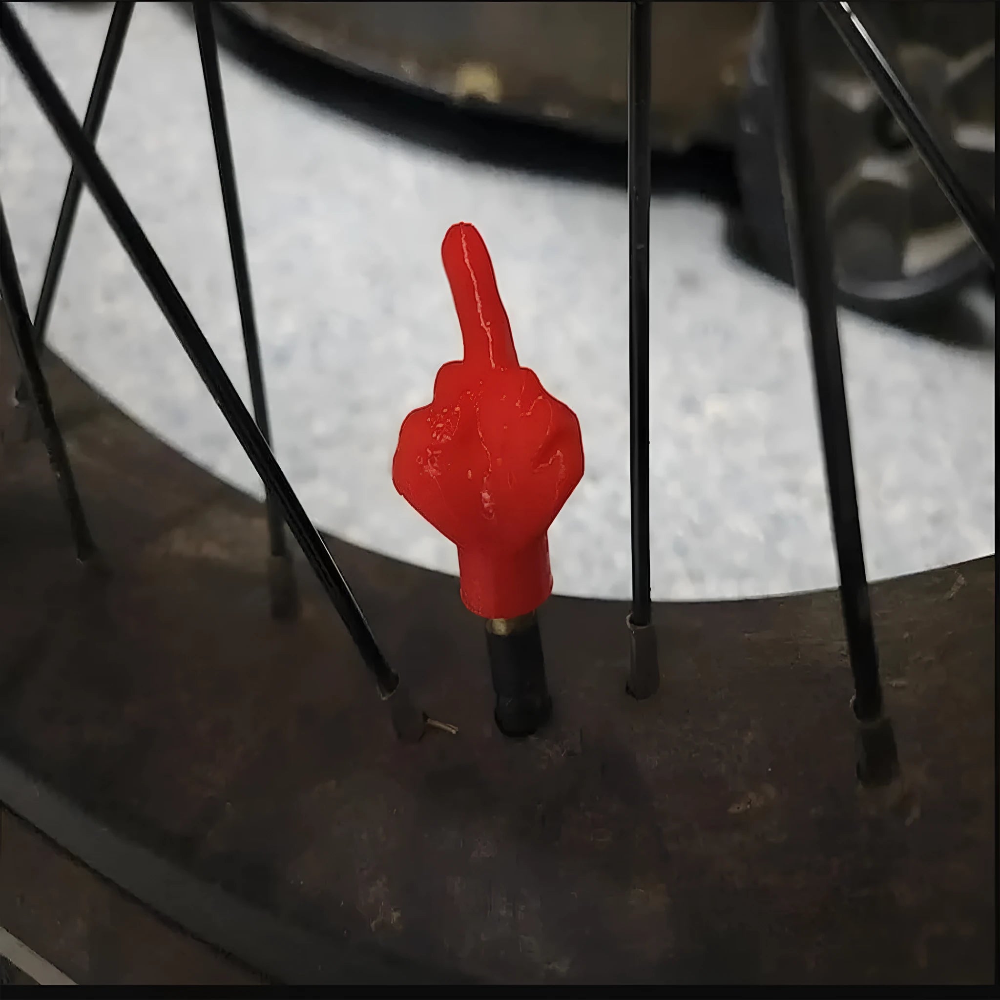 Four latex car tyre valve dust caps, shown in black and skin colour, arranged on a surface.