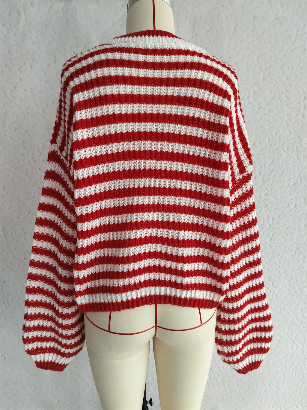 Women's loose black and white striped pullover sweater with a round neck and long sleeves.