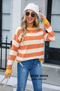 Woman wearing a loose blue and white striped acrylic sweater with long sleeves and a round neck.