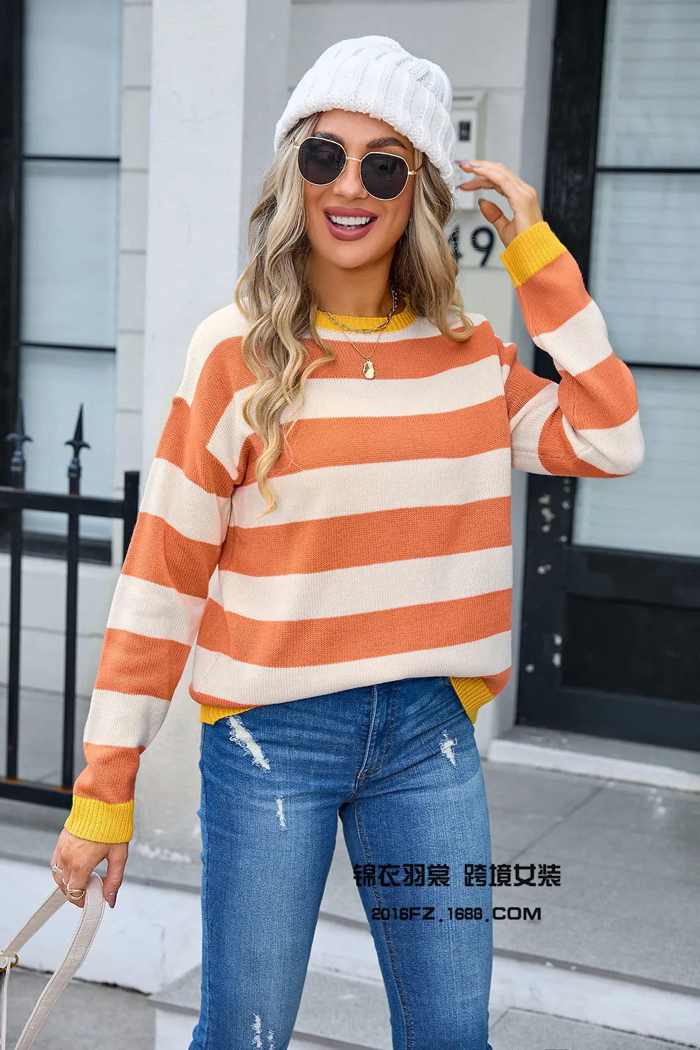 Woman wearing a loose blue and white striped acrylic sweater with long sleeves and a round neck.