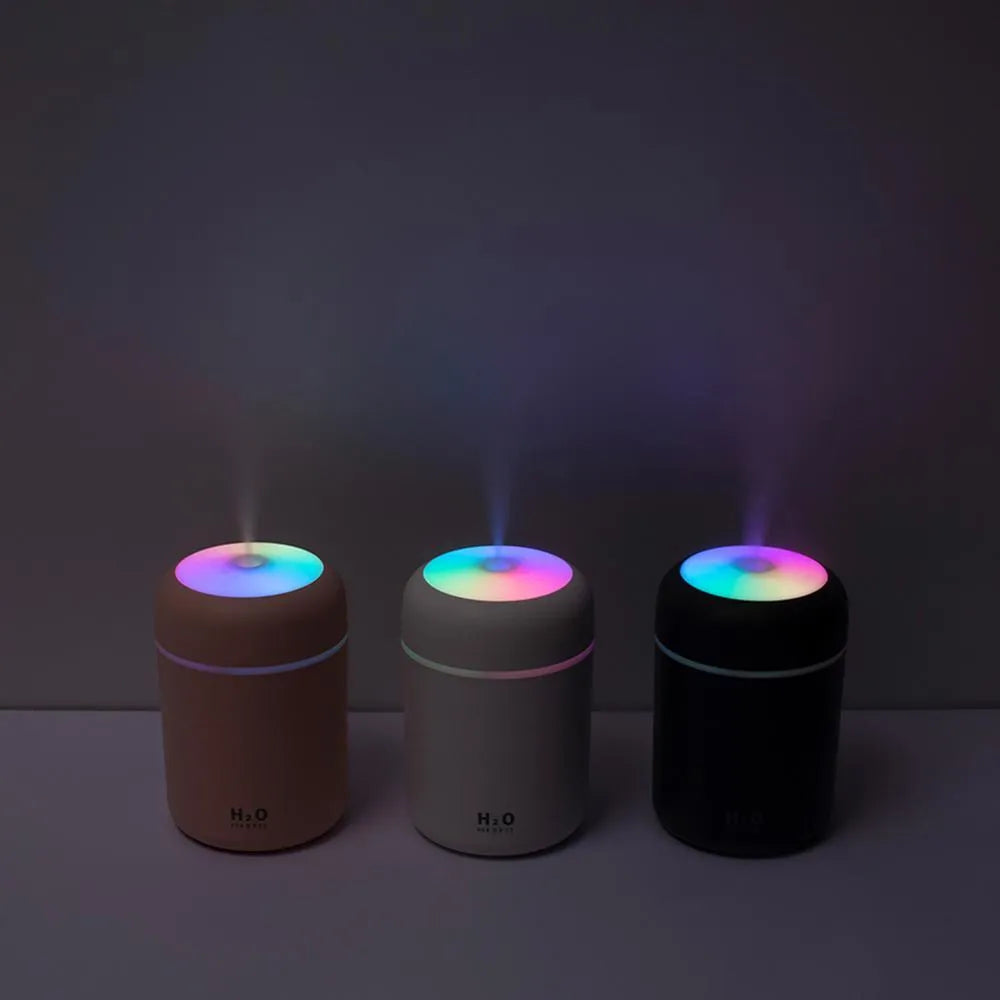 Pink, white, or navy blue USB desktop humidifier with colourful LED lights and water tank.