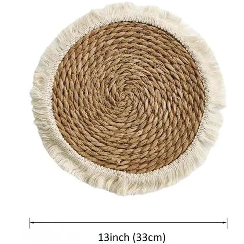 Round natural papyrus straw placemat with tassel detailing on a table.