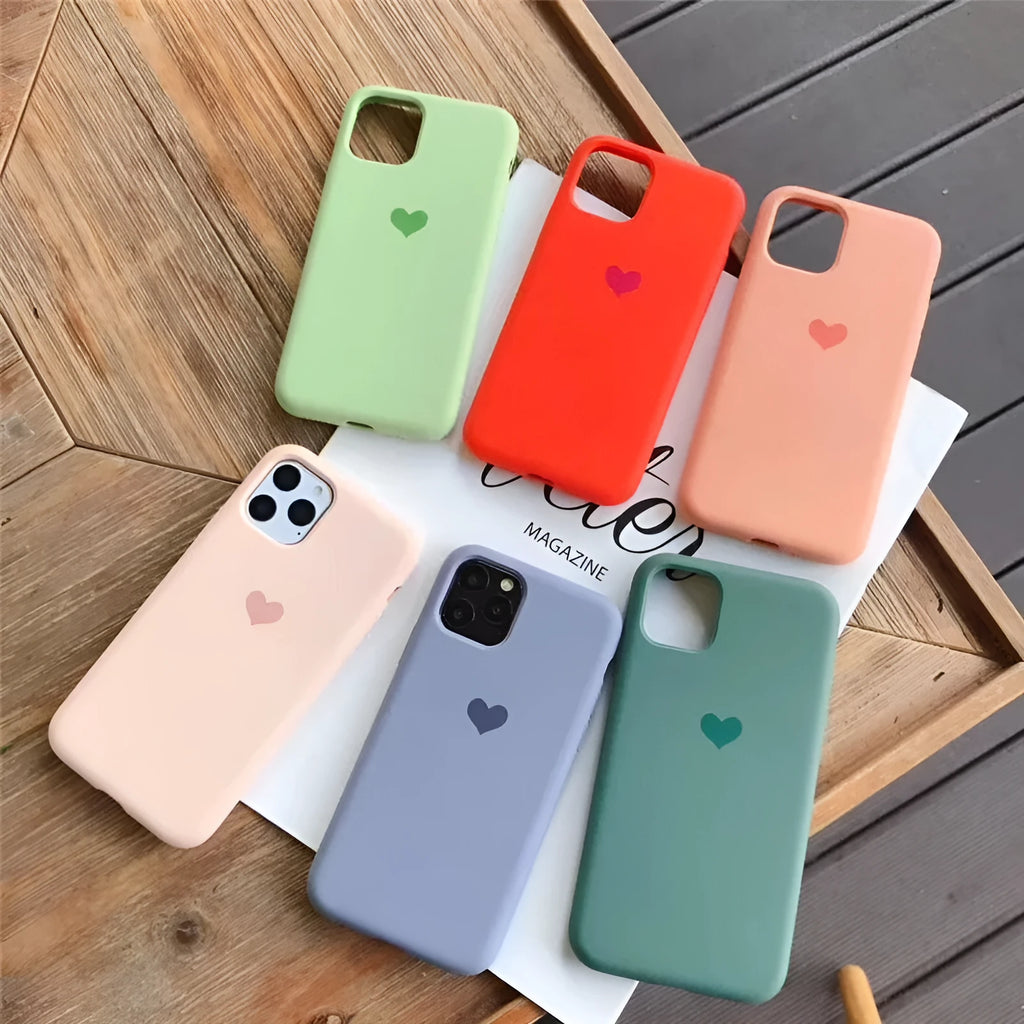 Solid colour silicone phone case for iPhone, shown in dark green, on a table.