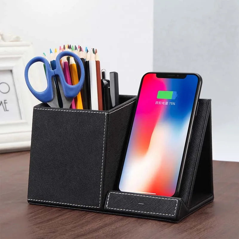 Black leather wireless charging station with pen holder slots showing phone charging on surface