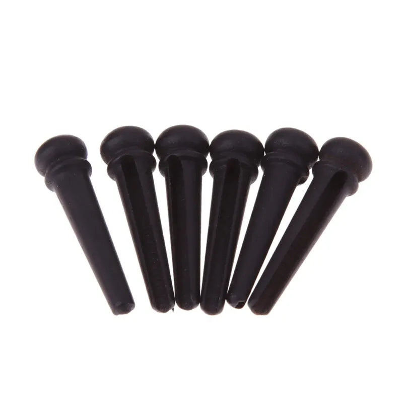 Six ebony guitar string nails with matt black finish and 5.3mm bayonet diameter