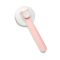 Blue self-cleaning slicker brush for dogs and cats on a wooden surface