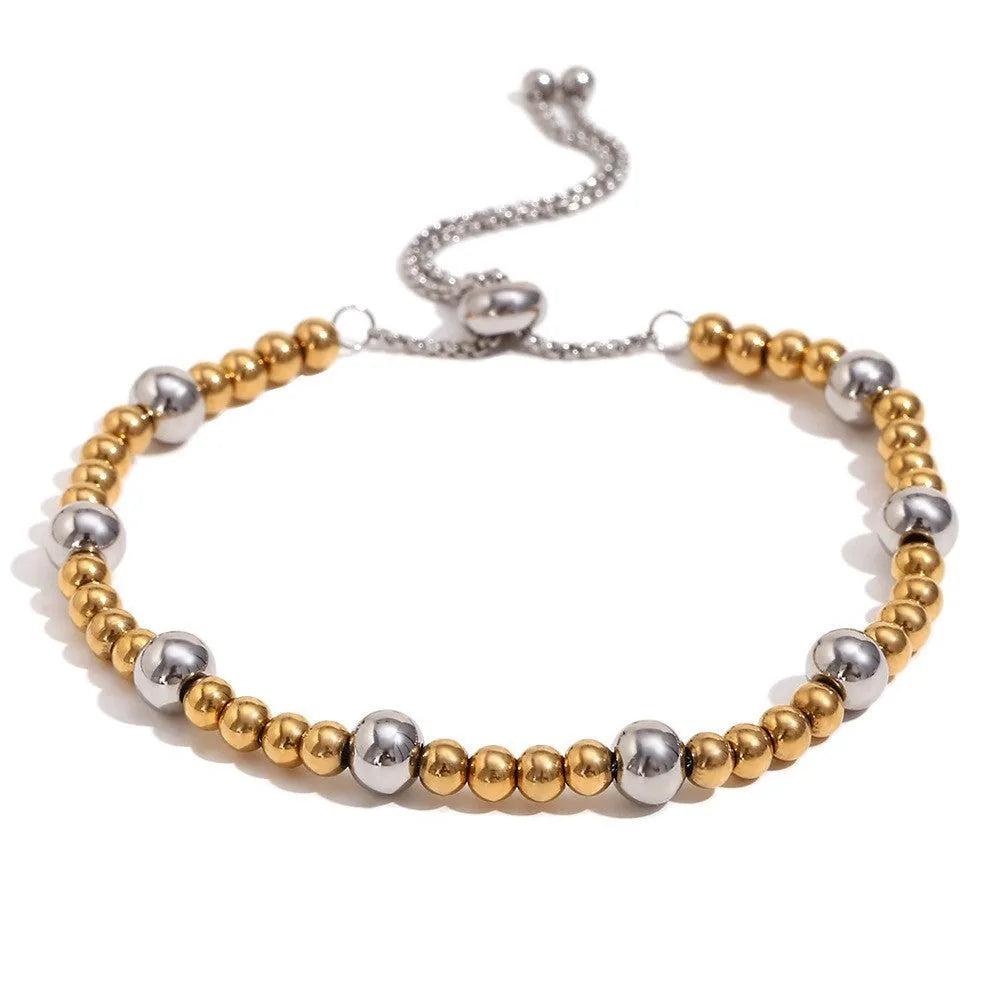 Women's stainless steel jewellery set with gold electroplated finish showing earrings, bracelet and necklace with geometric designs
