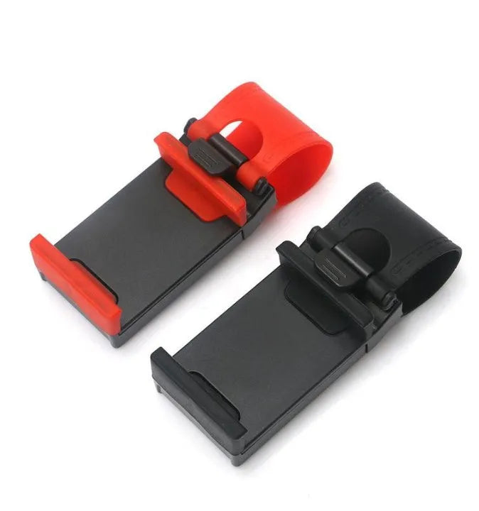 Black steering wheel phone mount holder clipped to a car wheel, holding a large smartphone.