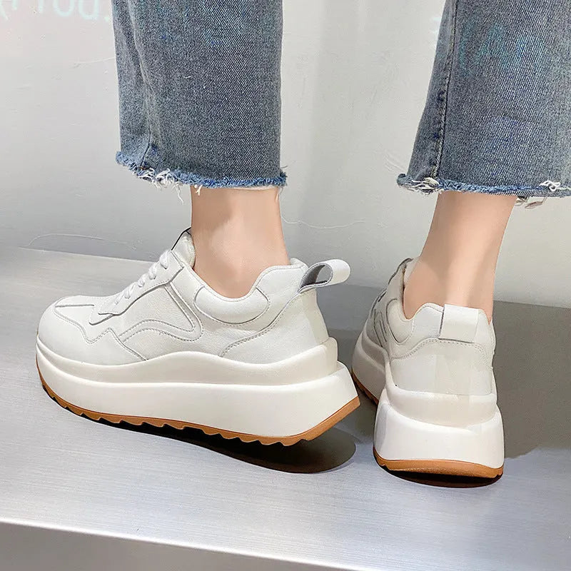 Beige women's cowhide leather low-top sports shoes with cross-strap and visible stitching on a round toe.