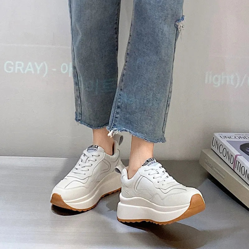 Beige women's cowhide leather low-top sports shoes with cross-strap and visible stitching on a round toe.