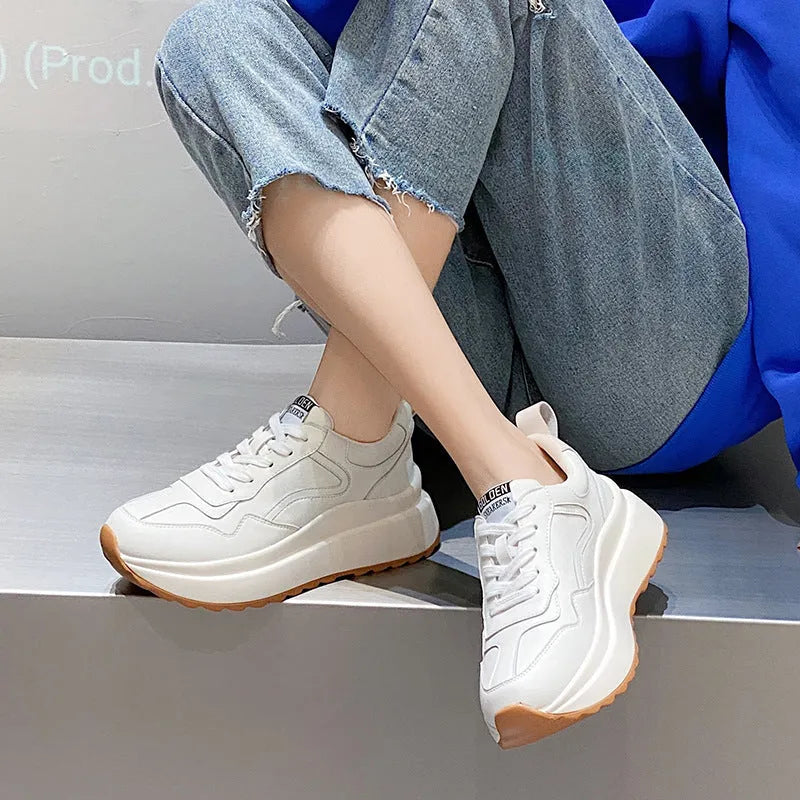 Beige women's cowhide leather low-top sports shoes with cross-strap and visible stitching on a round toe.
