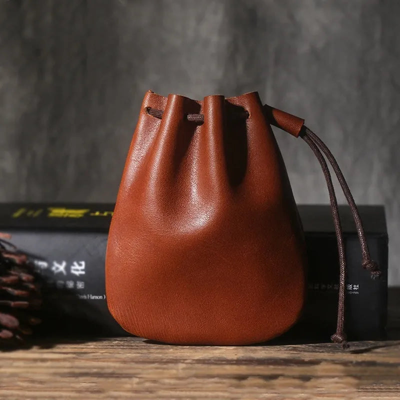 Genuine cowhide drawstring bundle wallet in retro style showing drawstring closure and sewing thread detail.