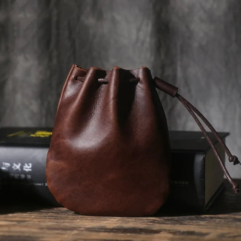 Genuine cowhide drawstring bundle wallet in retro style showing drawstring closure and sewing thread detail.