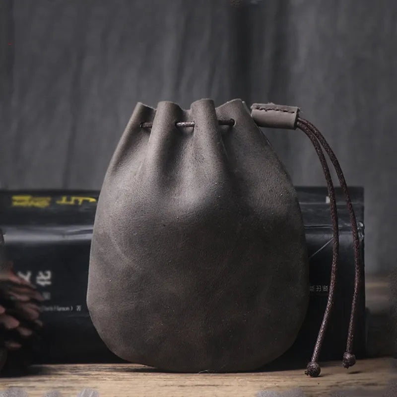 Genuine cowhide drawstring bundle wallet in retro style showing drawstring closure and sewing thread detail.