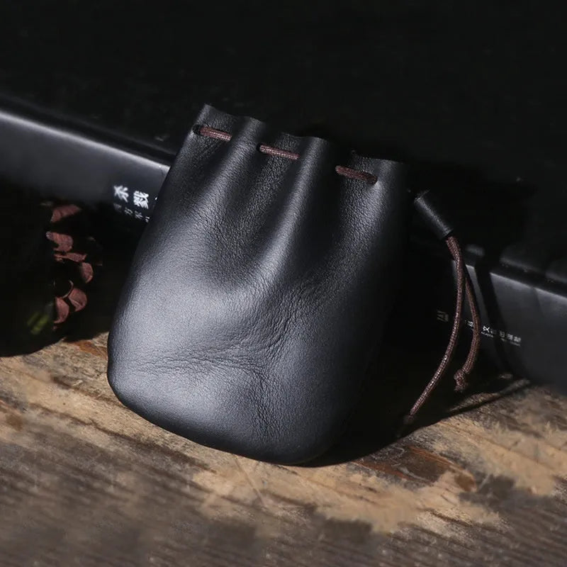 Genuine cowhide drawstring bundle wallet in retro style showing drawstring closure and sewing thread detail.