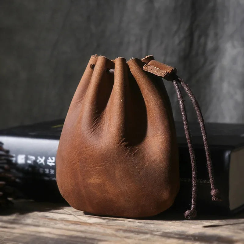 Genuine cowhide drawstring bundle wallet in retro style showing drawstring closure and sewing thread detail.