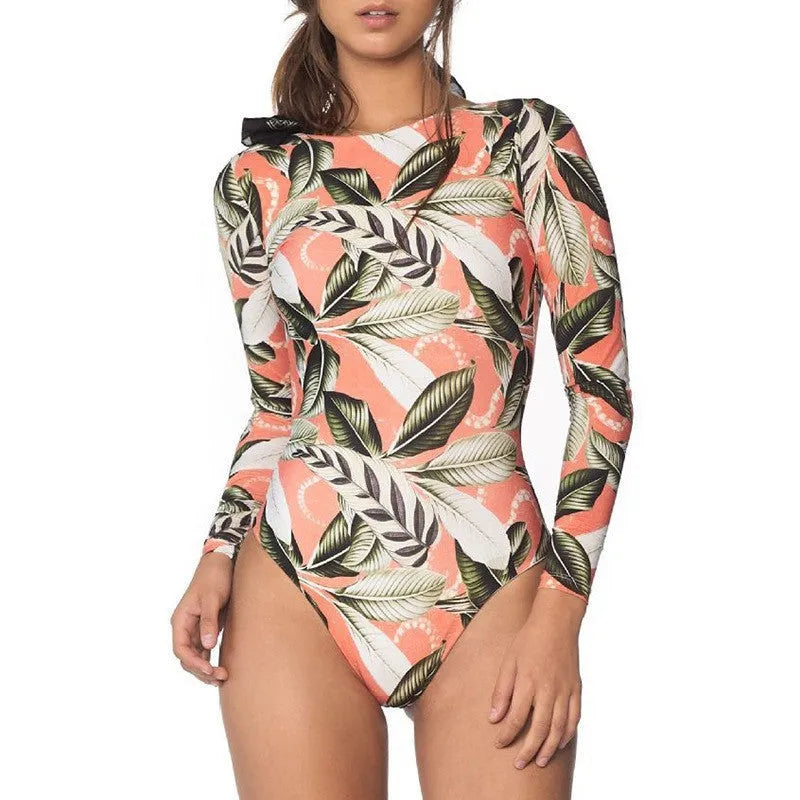 Women's one-piece swimsuit with green leaf print on a dark background, conservative cut.