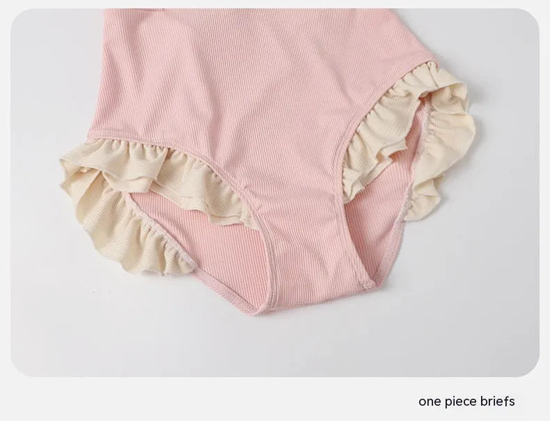 Pink women's one-piece swimsuit with conservative cut and Siamese cute design on a hanger.