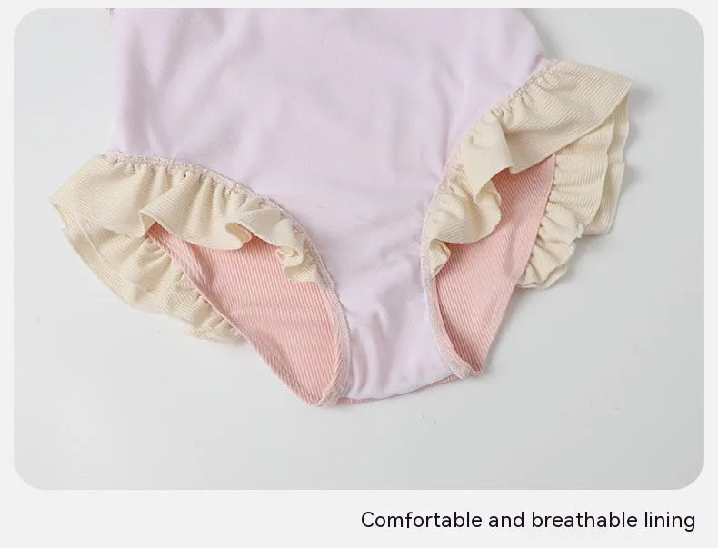 Pink women's one-piece swimsuit with conservative cut and Siamese cute design on a hanger.