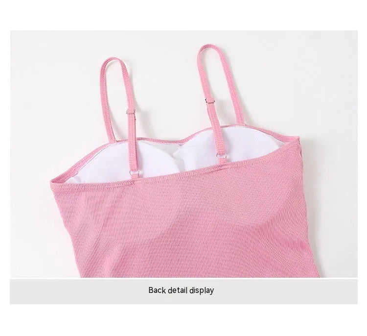 Women's pink and black long sleeve one-piece swimsuit on a hanger